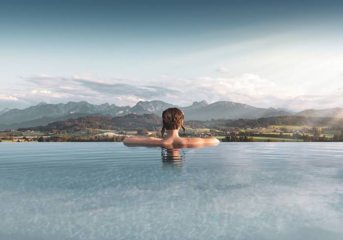 Frau im Panorama-Pool mit Berg-Blick